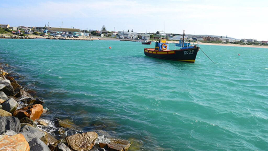 Escape to the pristine shores of Struisbaai Beach, a coastal haven where white sands stretch along turquoise waters